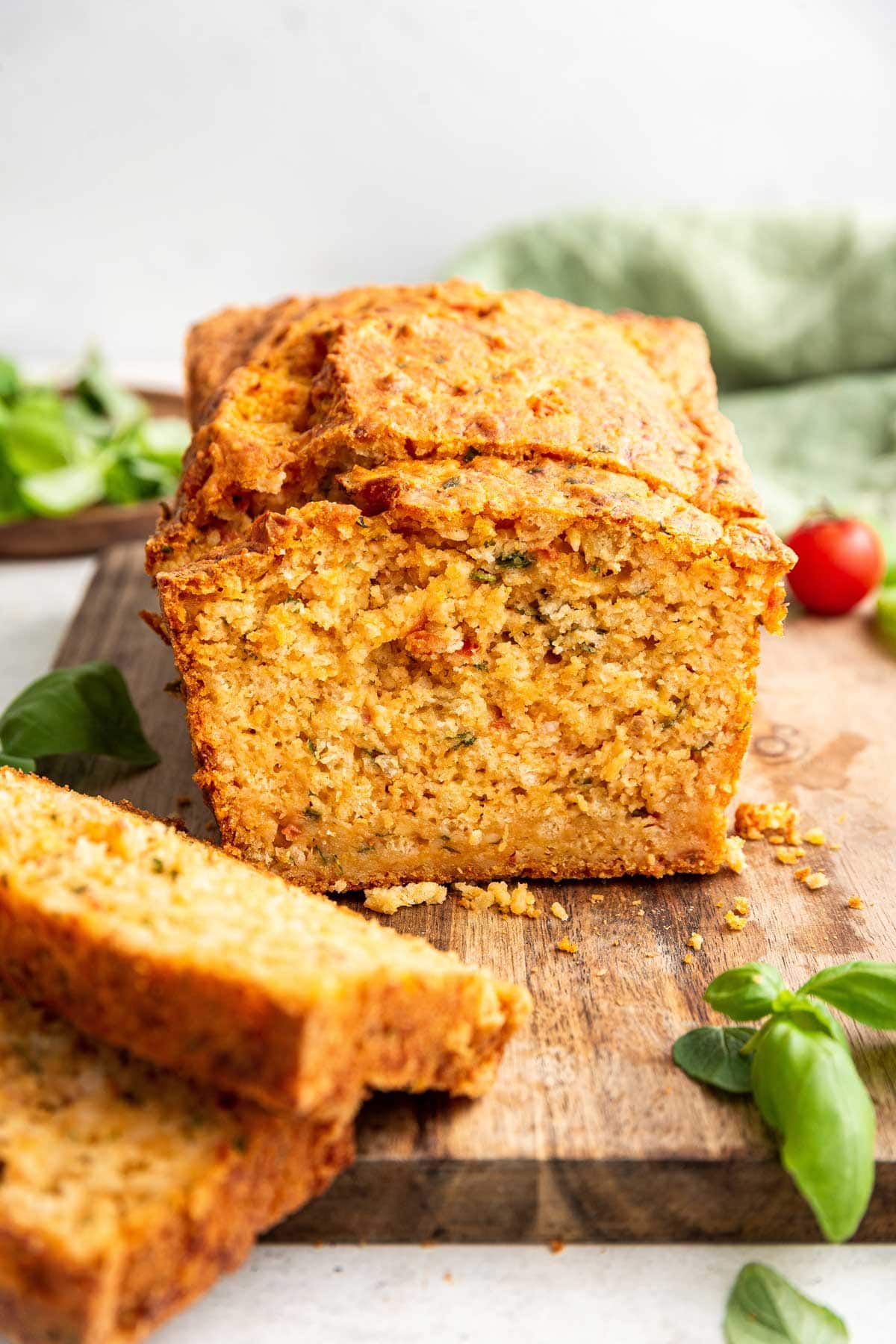 front on view of a cut loaf of italian herb tomato bread made with fresh tomatoes and herbs