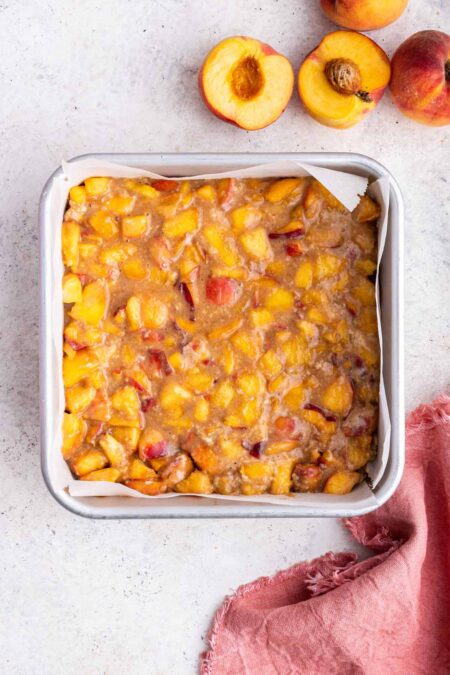 homemade peach pie filling spread into a baking dish