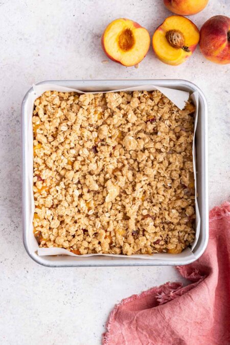 peach pie bars covered with oatmeal crumble ready to bake