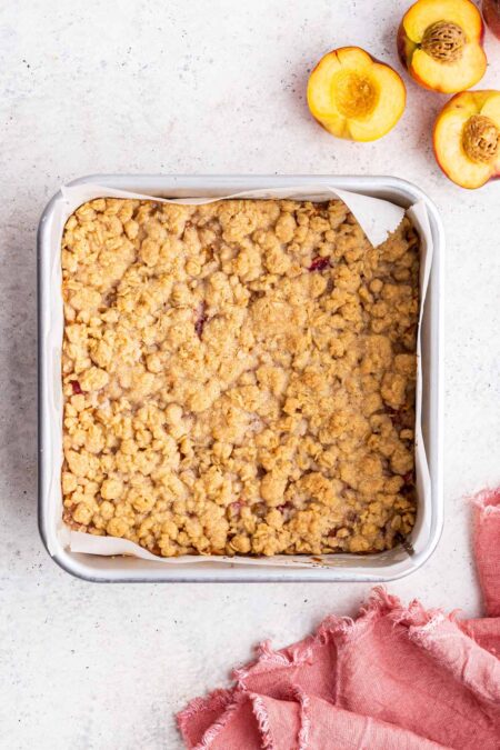 freshly baked peach pie bars with a golden oatmeal crumble topping