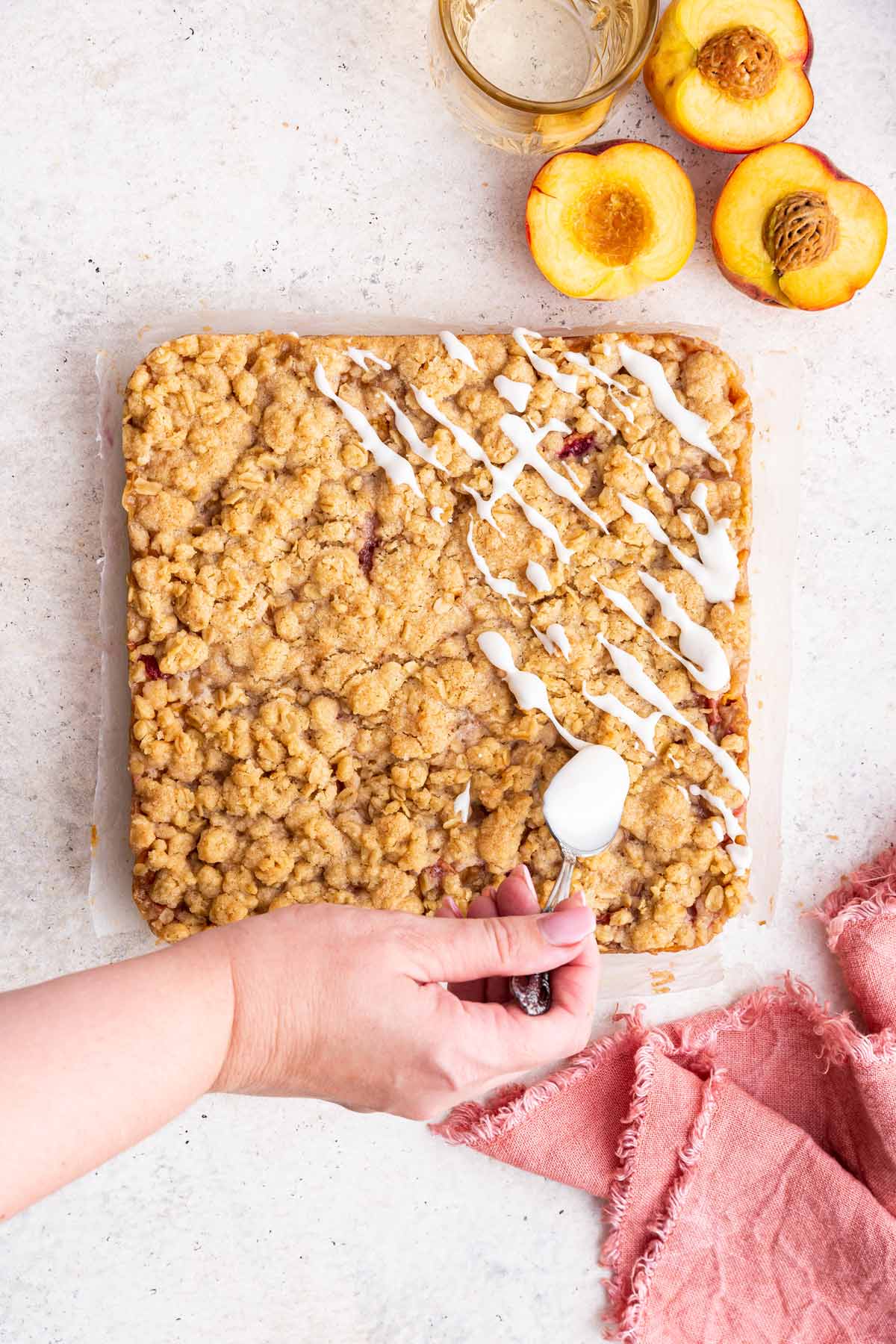 drizzling a sugar glaze on top of peach pie bars