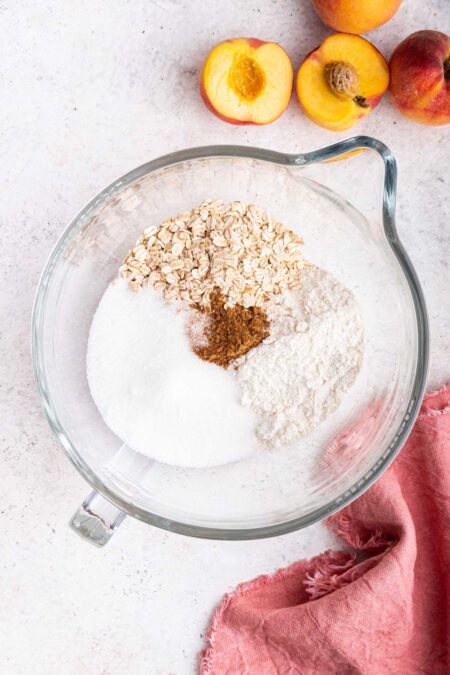 flour, sugar, and oats in a glass mixing bowl