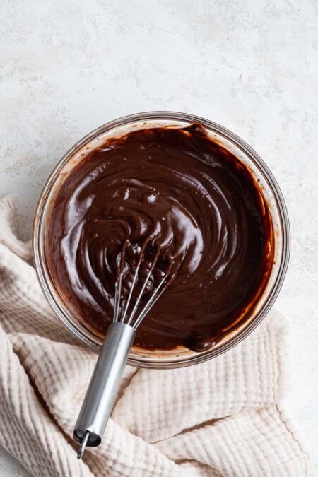 silky smooth chocolate ganache in a glass mixing bowl