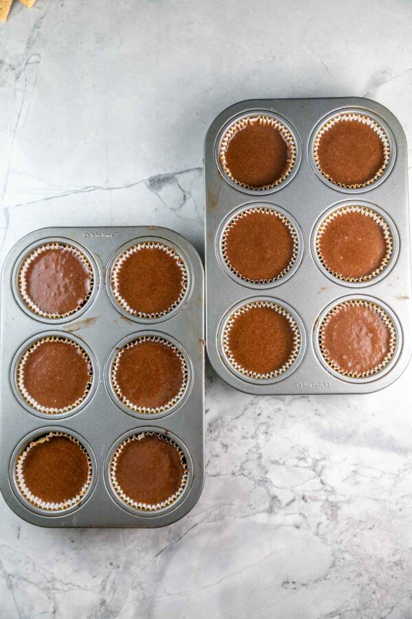 Cupcake tins filled with chocolate cupcake batter. 