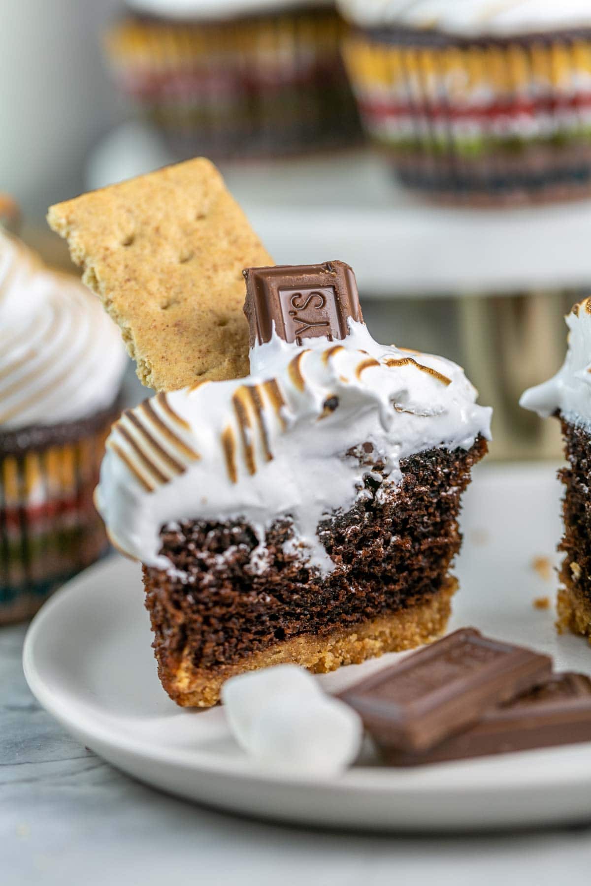 S'mores cupcake cut in half on a white plate.