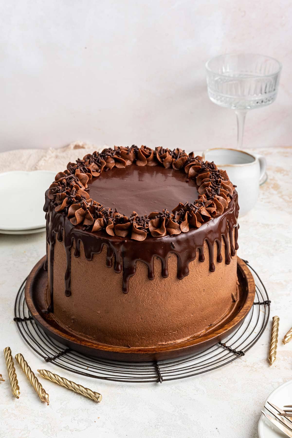 tall chocolate cake covered with chocolate frosting and chocolate ganache dripping down the sides.