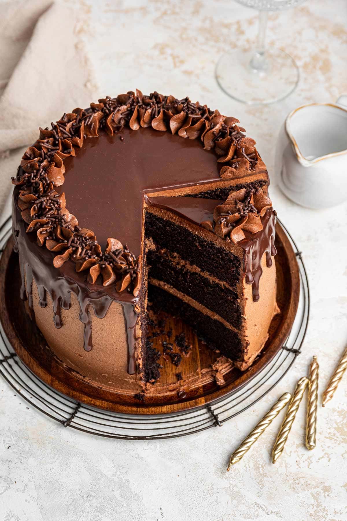 three layer chocolate cake with a slice removed.