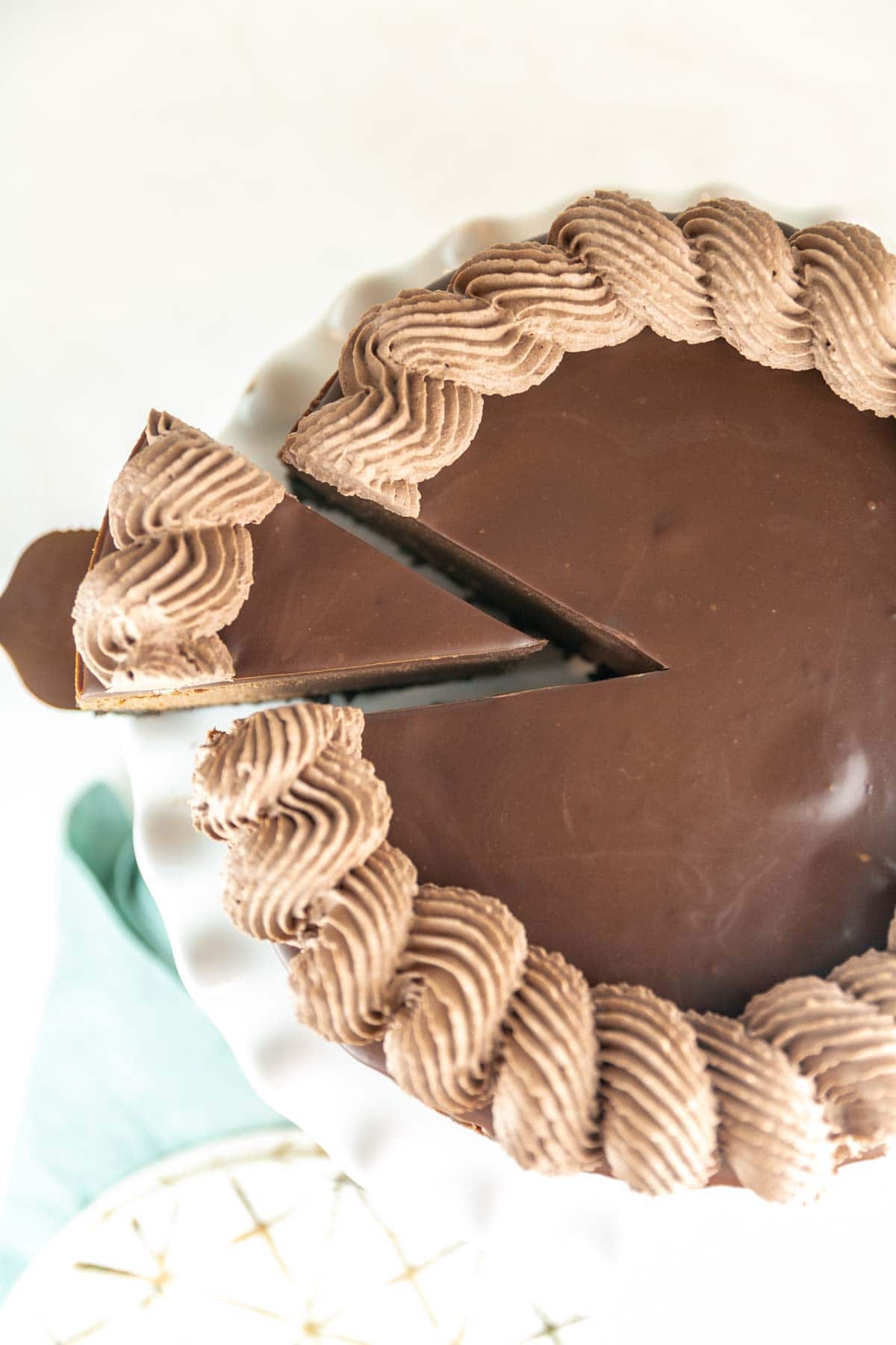 top view of a cheesecake covered with chocolate ganache and swirled chocolate frosting.