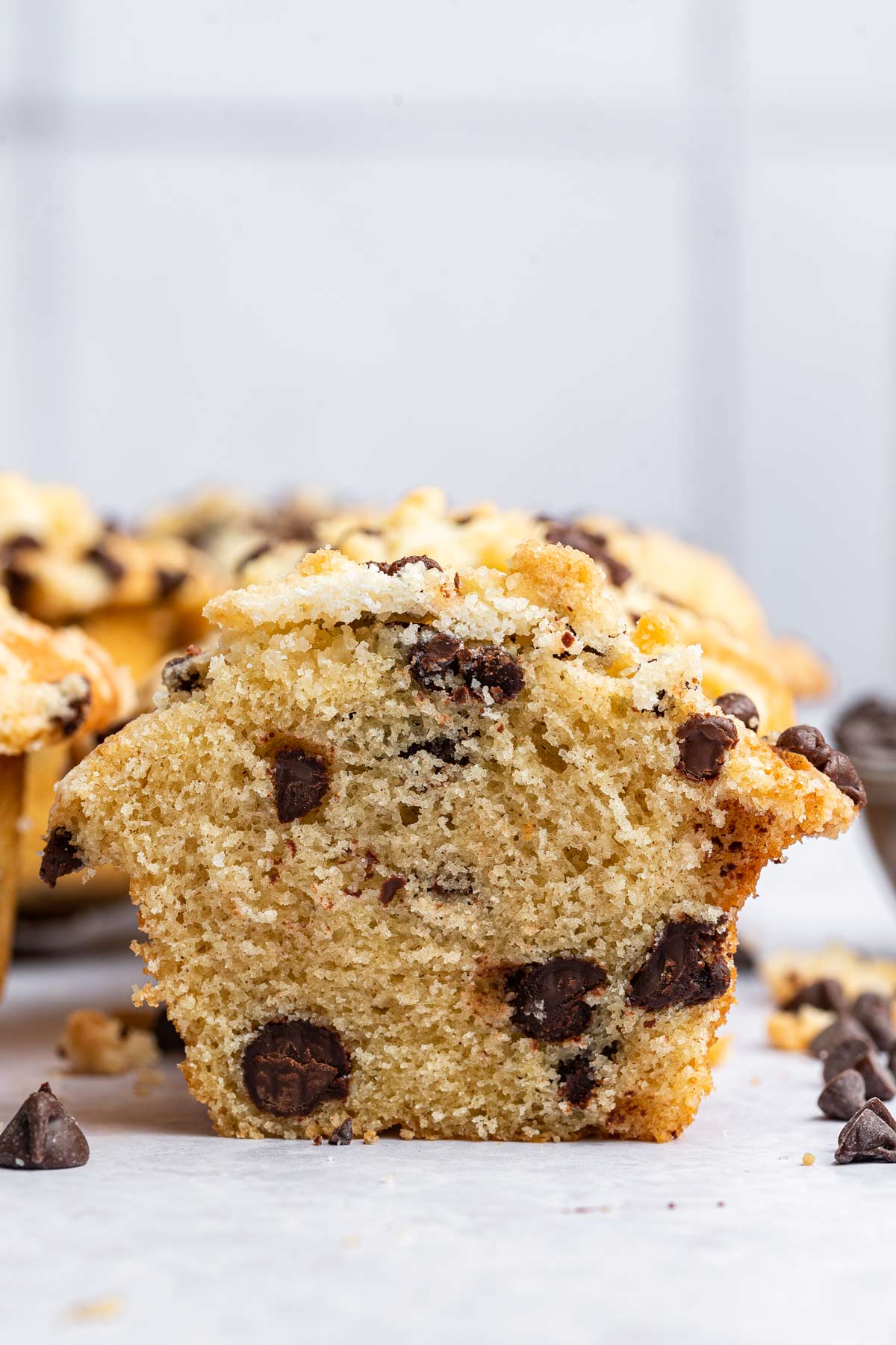 chocolate chip muffin cut in half showing the fluffy chocolate-chip filled interior