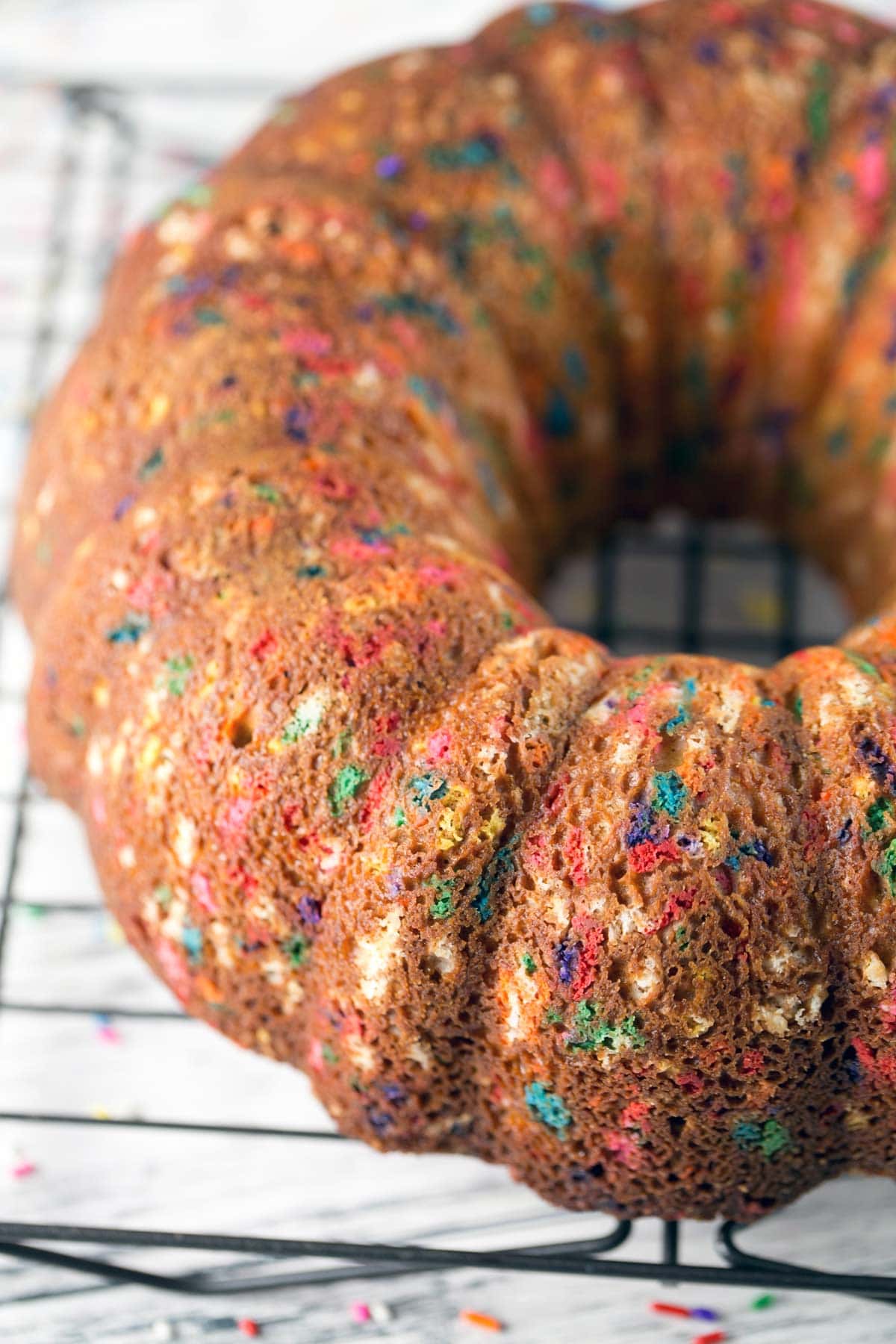 unglazed funfetti bundt cake full of sprinkles on a wire cooling rack.