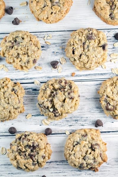 overhead view of oatmeal chocolate chip cookies lined up on a wooden table.