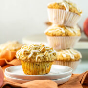 peach ginger muffins with a crumb topping and a vanilla glaze.