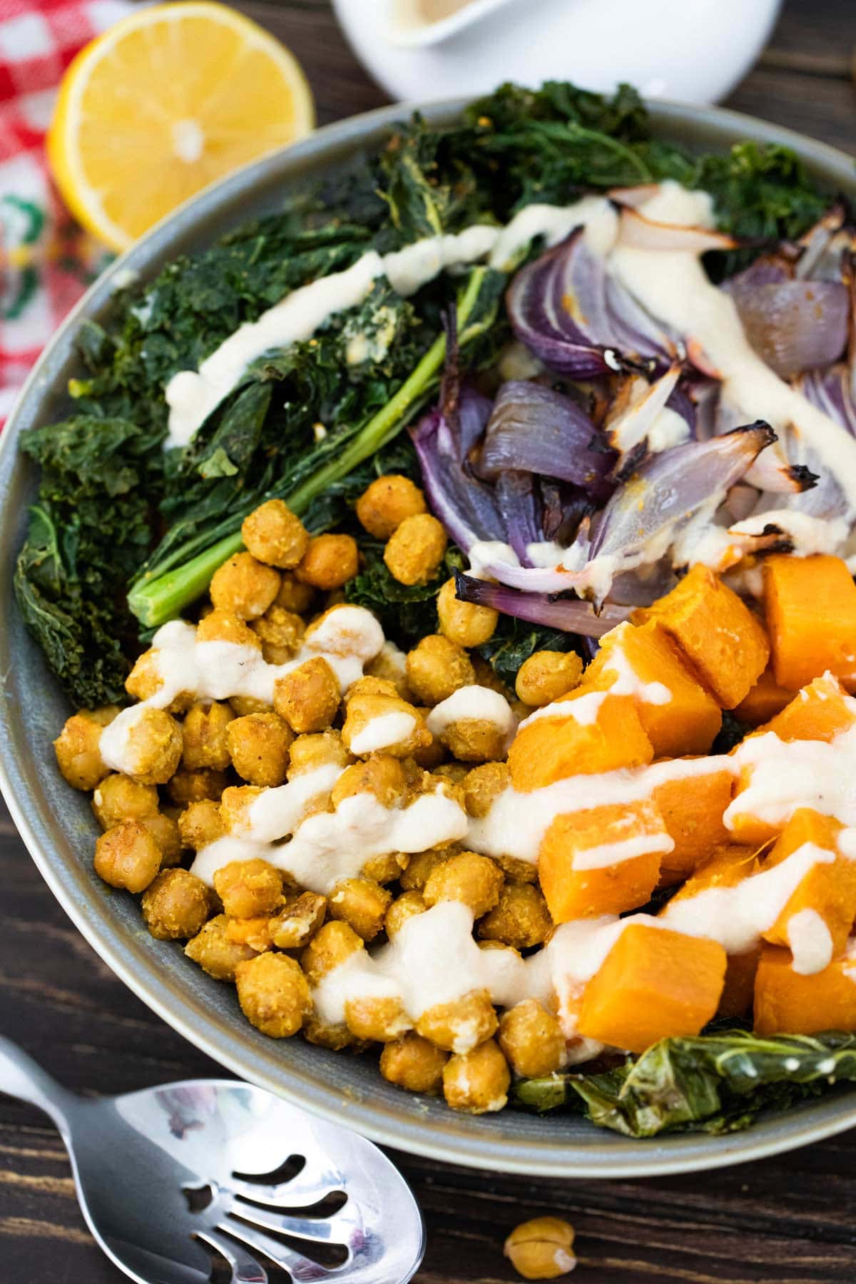 bowl of kale with sections of sweet potatoes, red onions, and chickpeas.