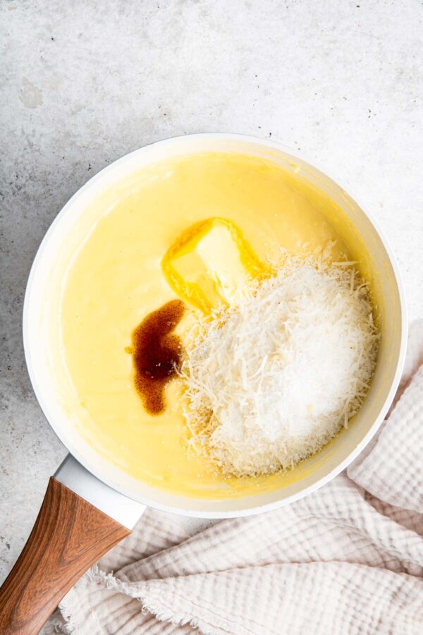 adding butter and shredded coconut to a cooked custard.