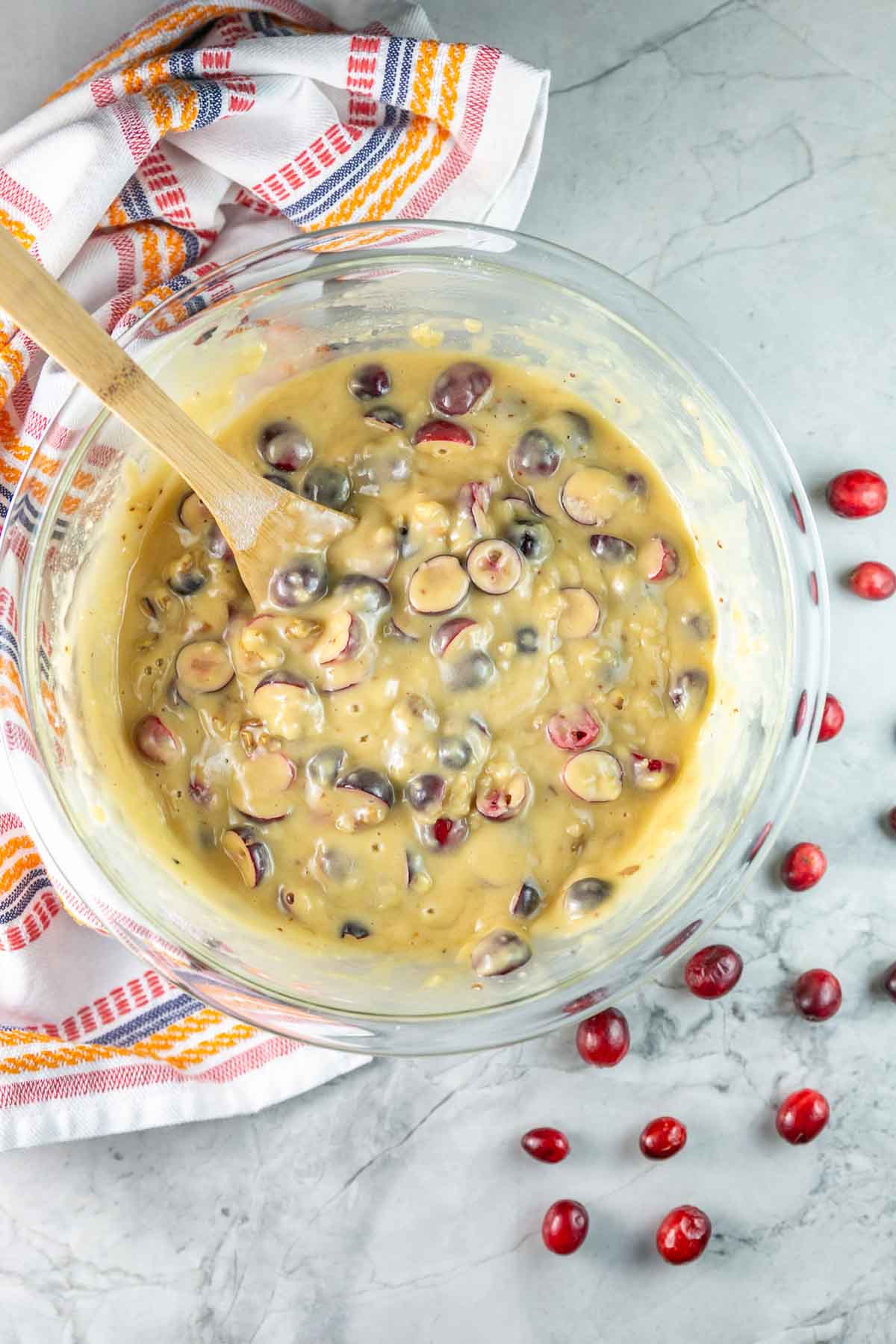 glass mixing bowl filled with quick bread batter.