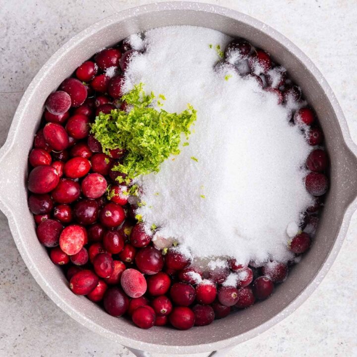 saucepan filled with cranberries, sugar, and lime zest