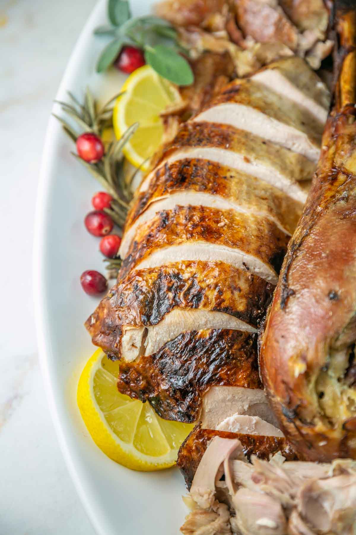 Side view of roasted and caved turkey on a serving platter.