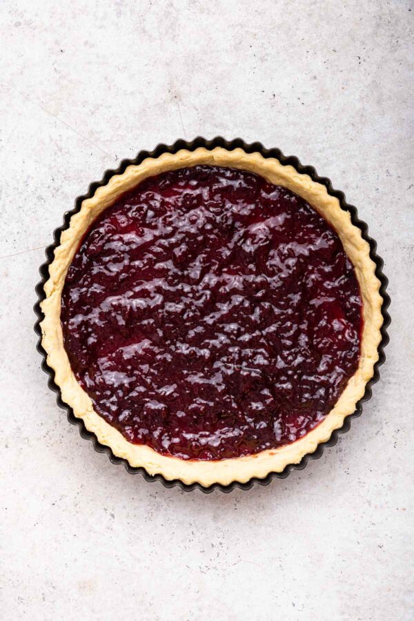 shortbread crust in a tart pan filled with a layer of thick cherry jam.