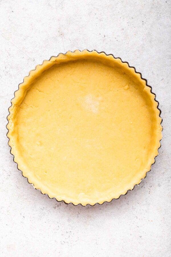 unbaked shortbread crust in a fluted tart pan.