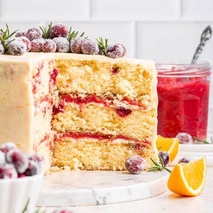 side view of a three layer cranberry orange cake filled with cranberry curd.