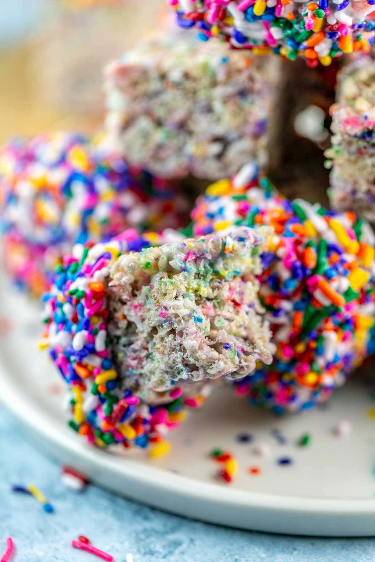 rectangular rice krispie treat with a bite taken out of it showing the sprinkle speckled interior.