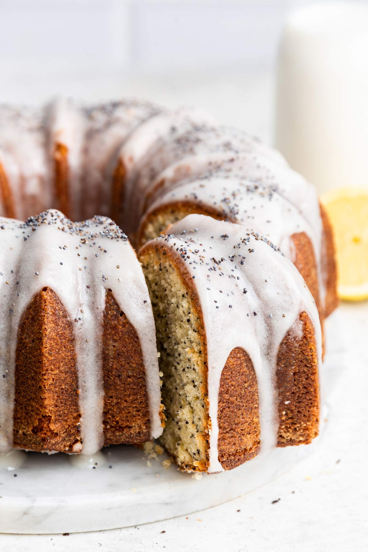 one slice of a lemon poppy seed pound cake cut out and removed from the rest of the cake.