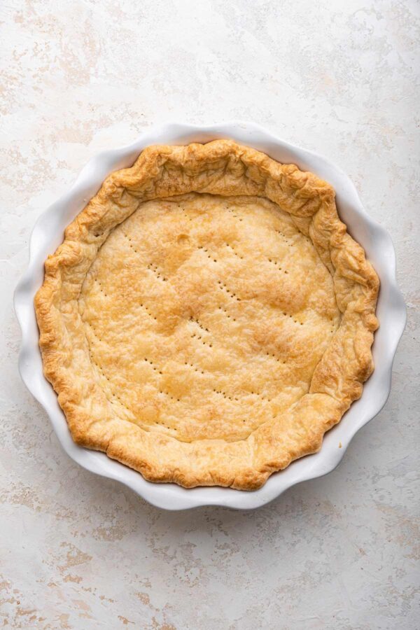 baked pie crust made from scratch in a white ceramic pie dish.