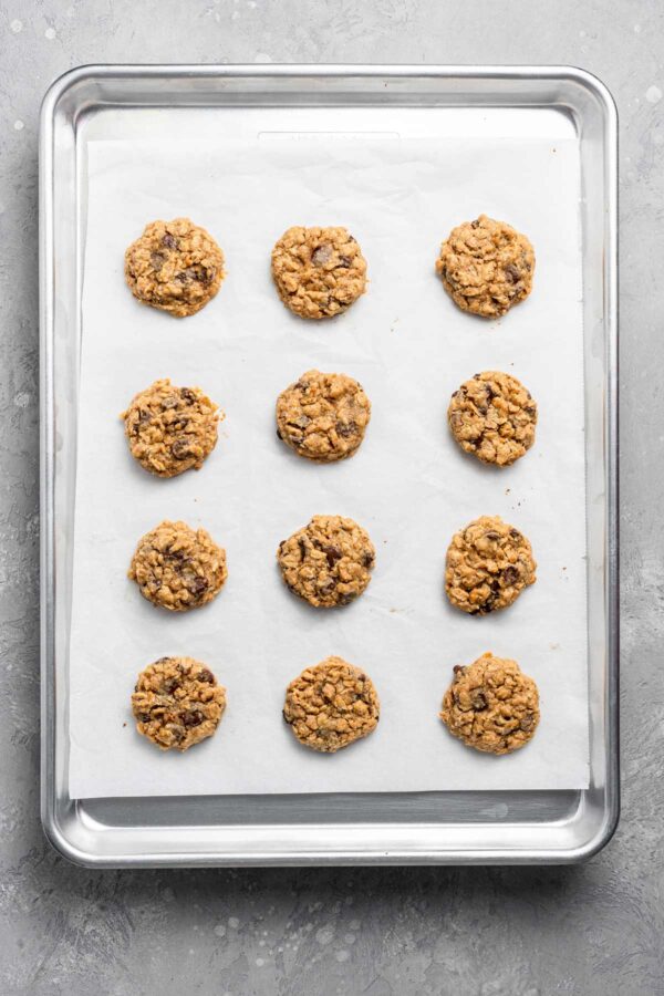 freshly baked chocolate chip lactation cookies on a parchment lined cookie sheet.