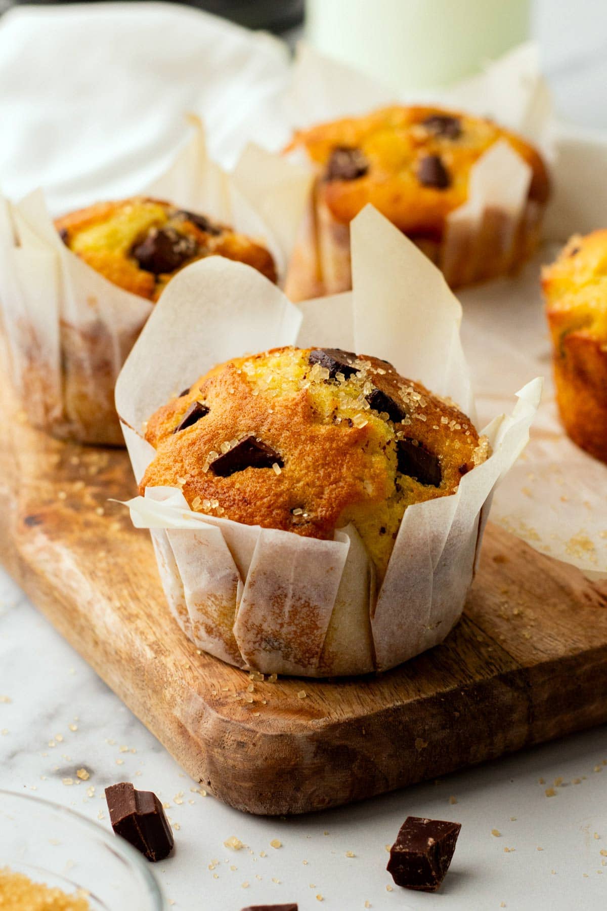 brown butter chocolate chunk muffin in white tulip muffin paper.