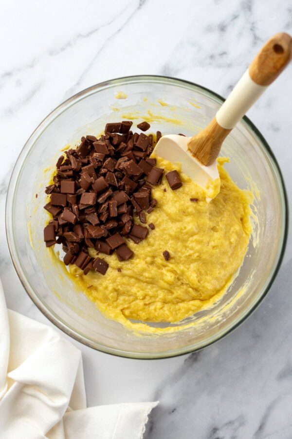 chunks of chocolate on top of homemade muffin batter. 
