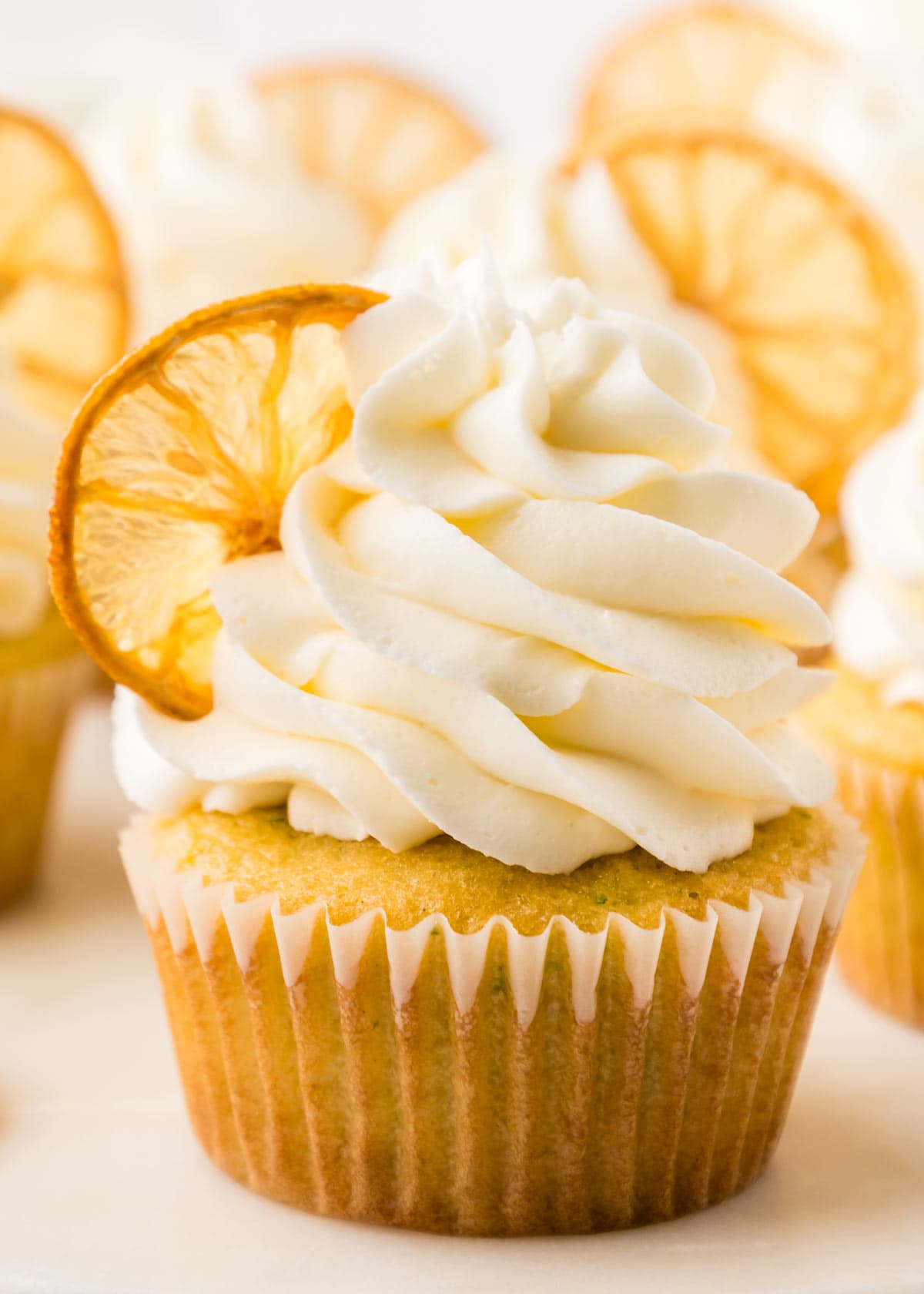 closeup of a lemon cupcake with zucchini with a big pile of piped lemon buttercream.