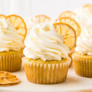 lemon zucchini cupcakes with a fluffy pile of lemon buttercream and a slice of candied lemon.