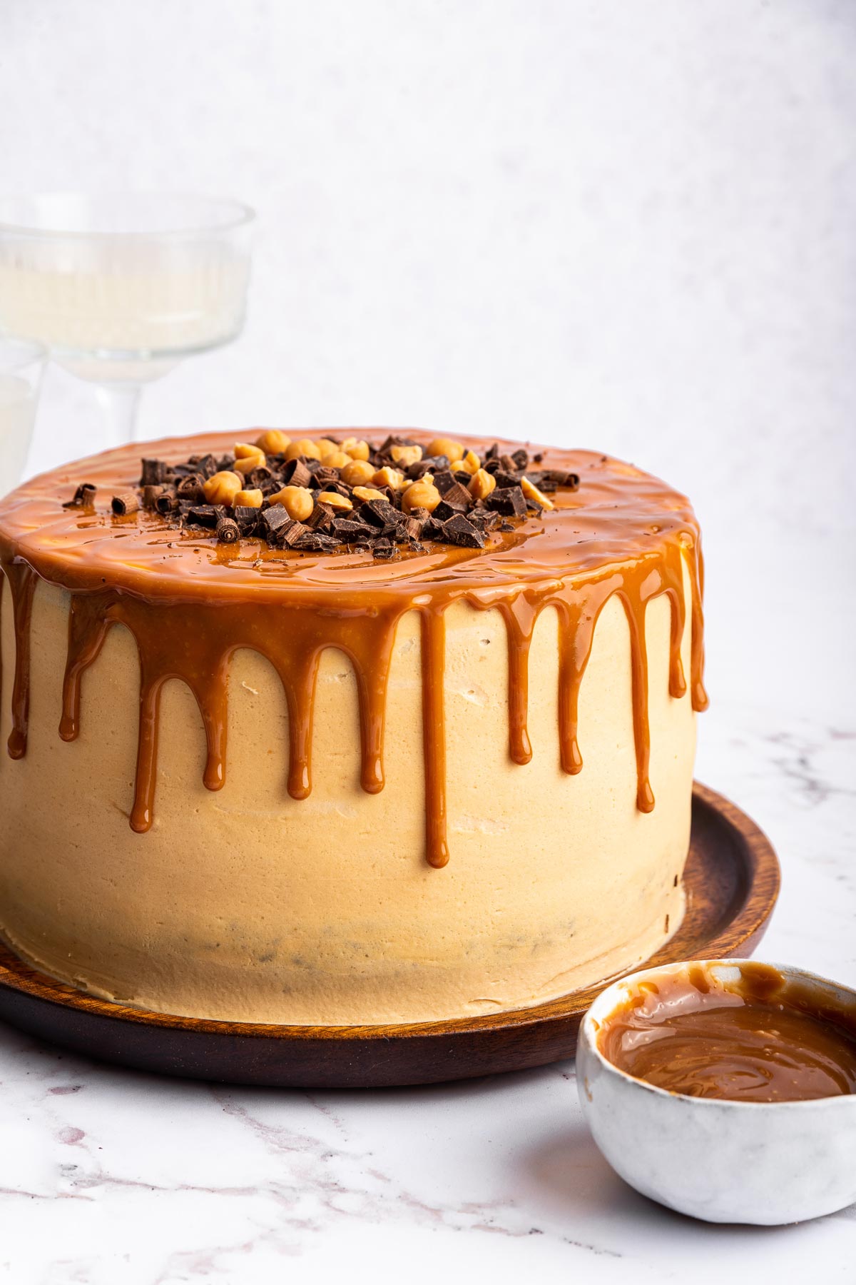 chocolate cake frosted with caramel buttercream covered with caramel drizzle and shaved chocolate. 