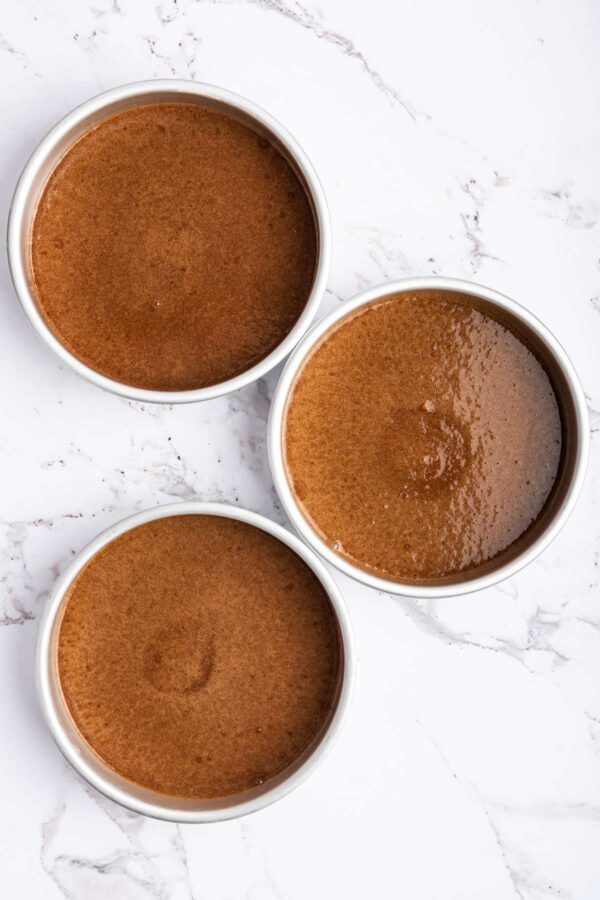 chocolate cake batter in three 8 inch cake pans.