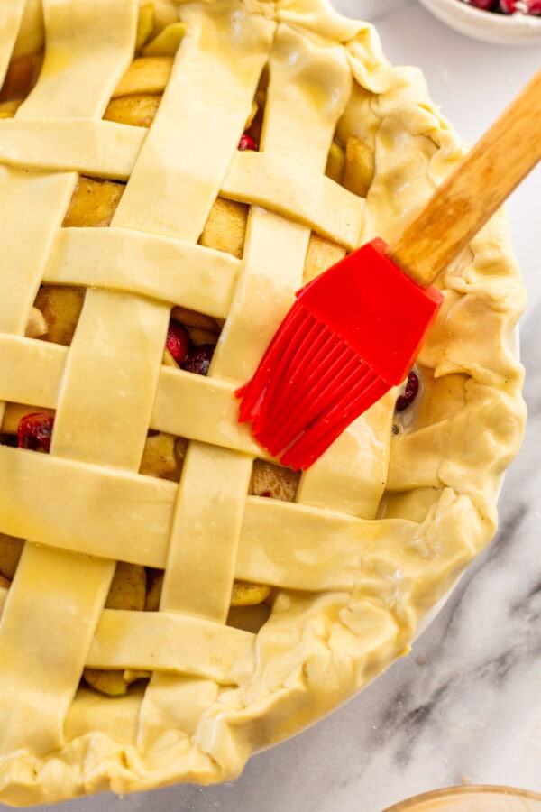 pastry brush brushin an egg wash on top of pie crust.