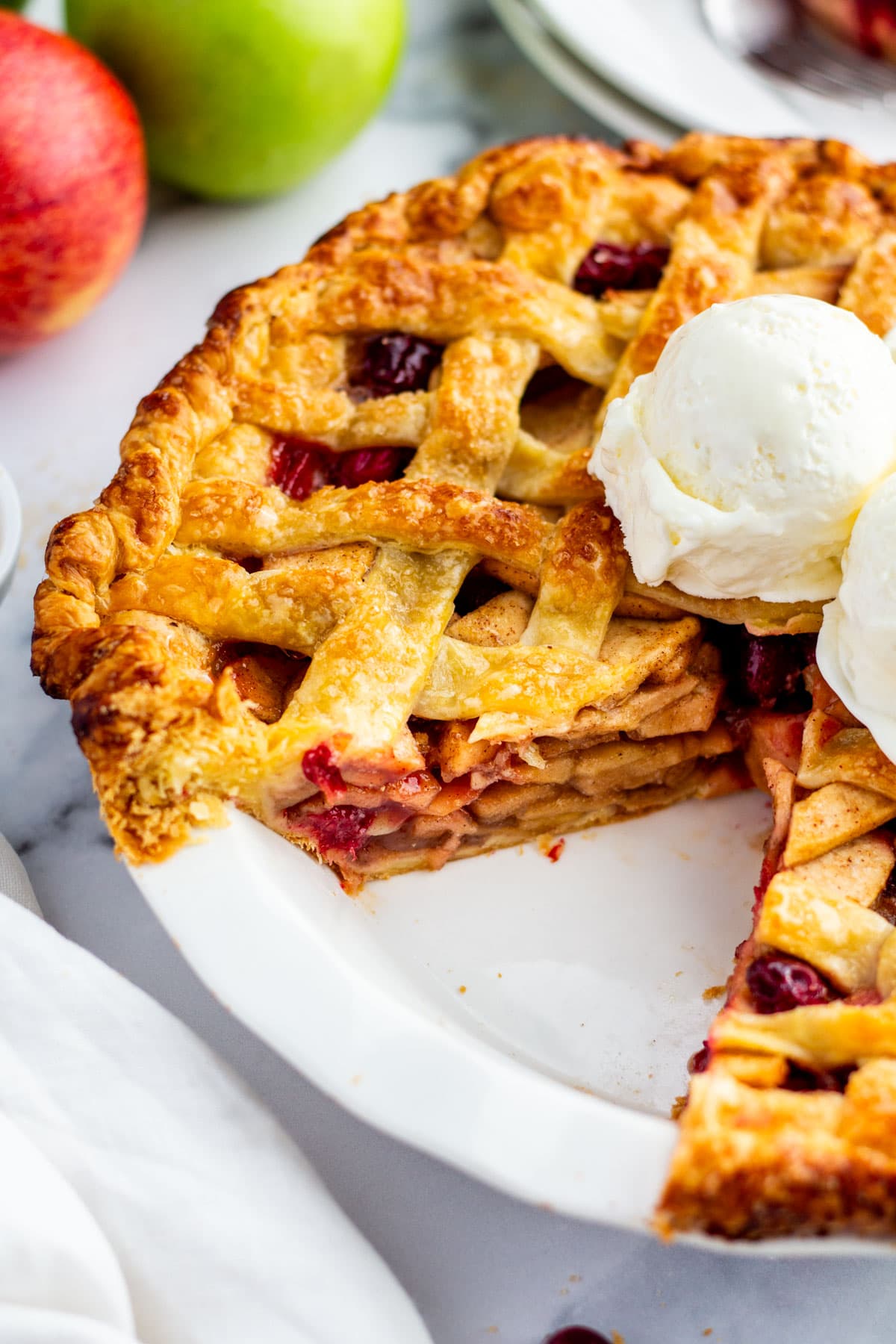 apple pie with two slices removed showing the layers of apples inside the pie.