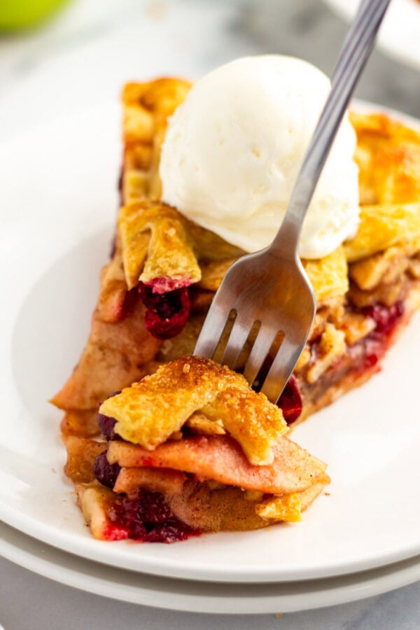 forkful of apple pie next to the rest of the slice.