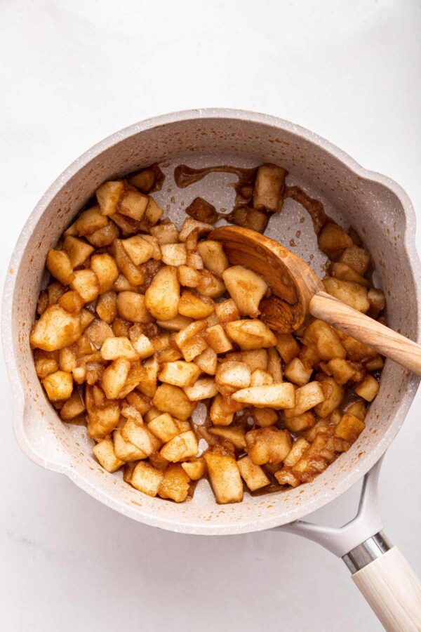 apples, cinnamon, and sugar cooking in a small saucepan.