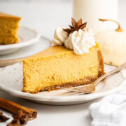 slice of creamy, smooth pumpkin cheesecake on a dessert plate.