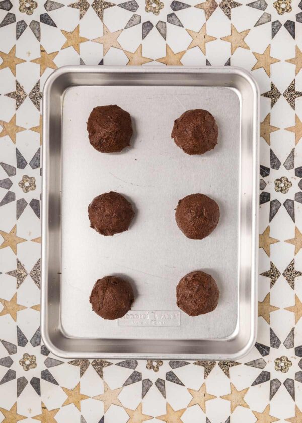 balls of cookie dough on a baking sheet.