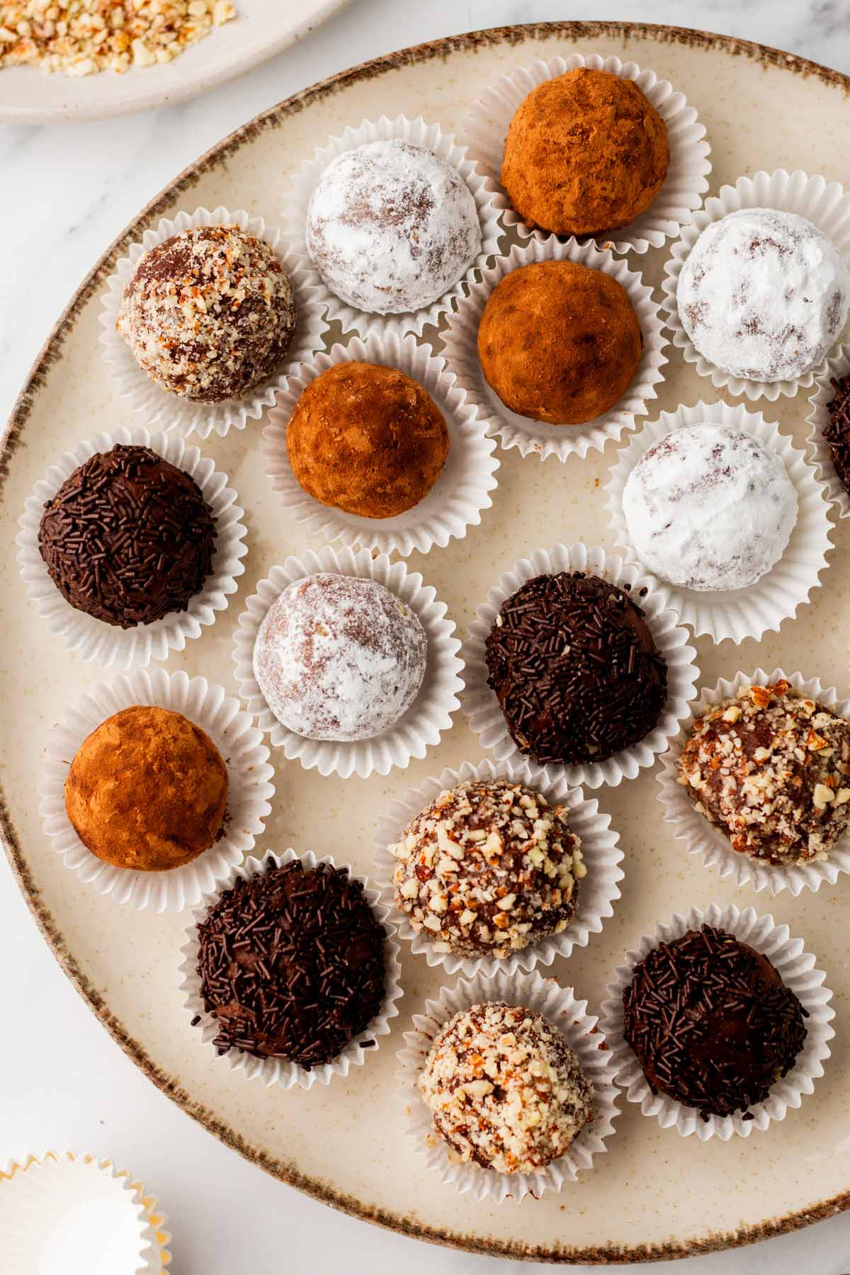 bourbon balls in paper wrappers arranged on a serving tray.