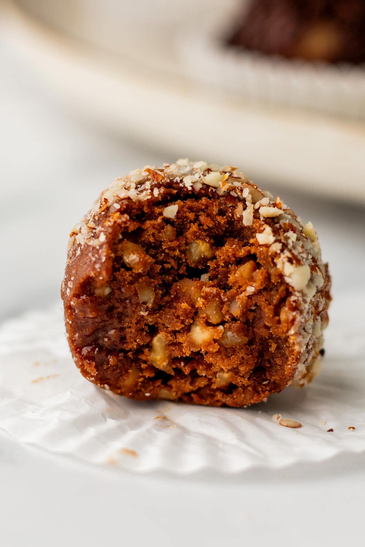 bourbon ball with a bite taken out of it showing the interior.