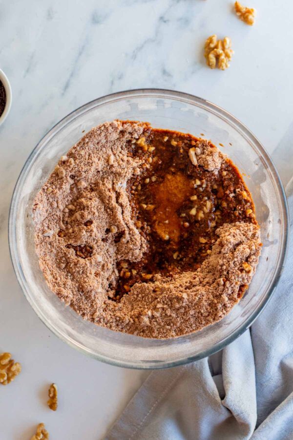 adding bourbon and honey to the dough to make bourbon balls.