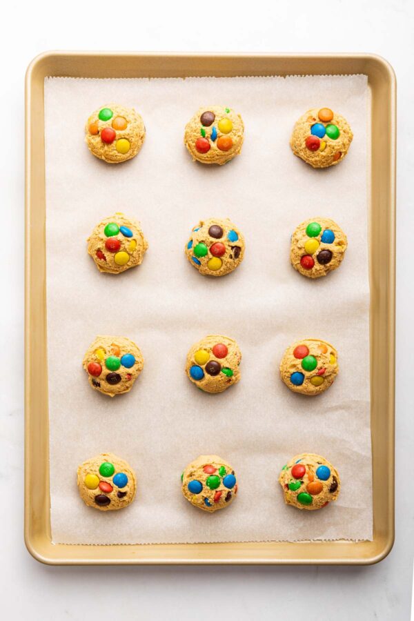 unbaked cookies on a parchment lined cookie sheet.