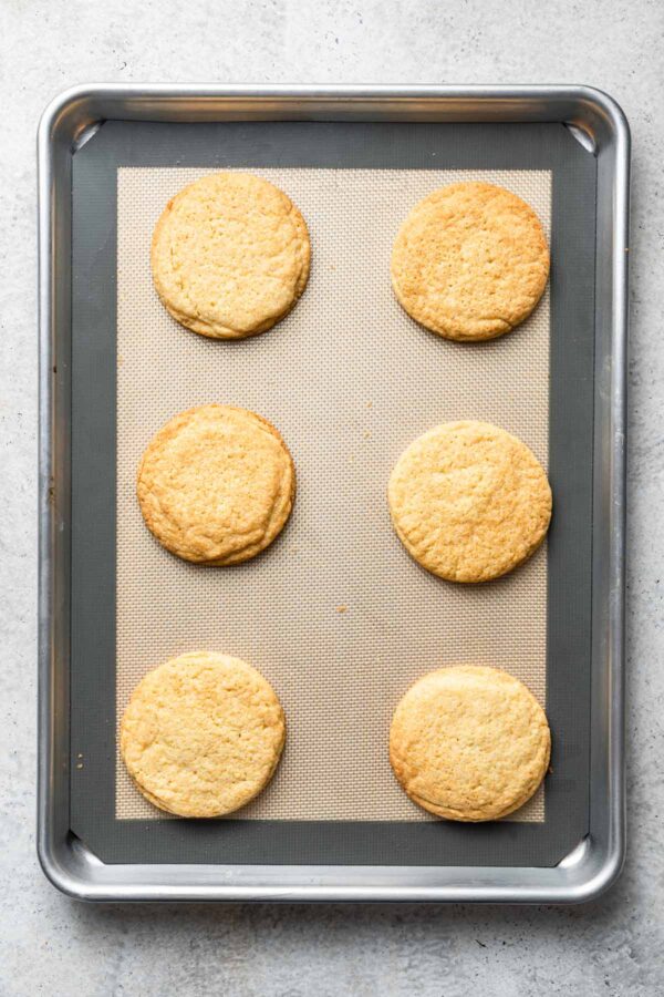 freshly baked black and white cookies on a cookie sheet.