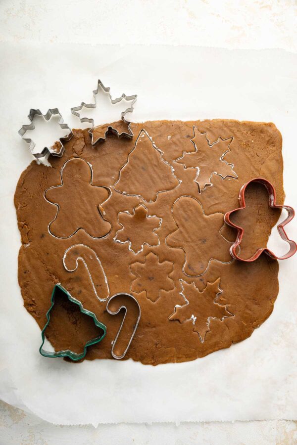 cutting out gingerbread dough with cookie cutters.