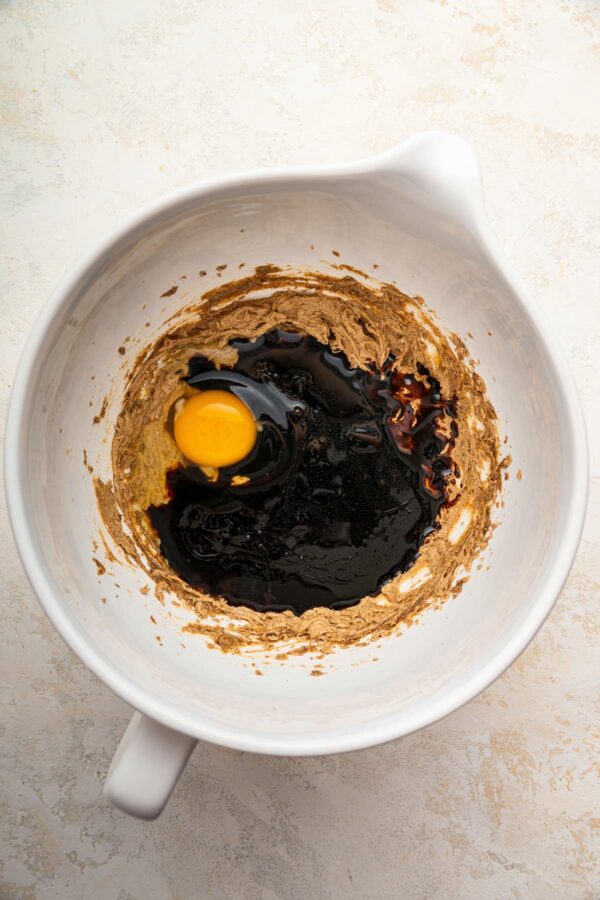 adding eggs and molasses to creamed butter.