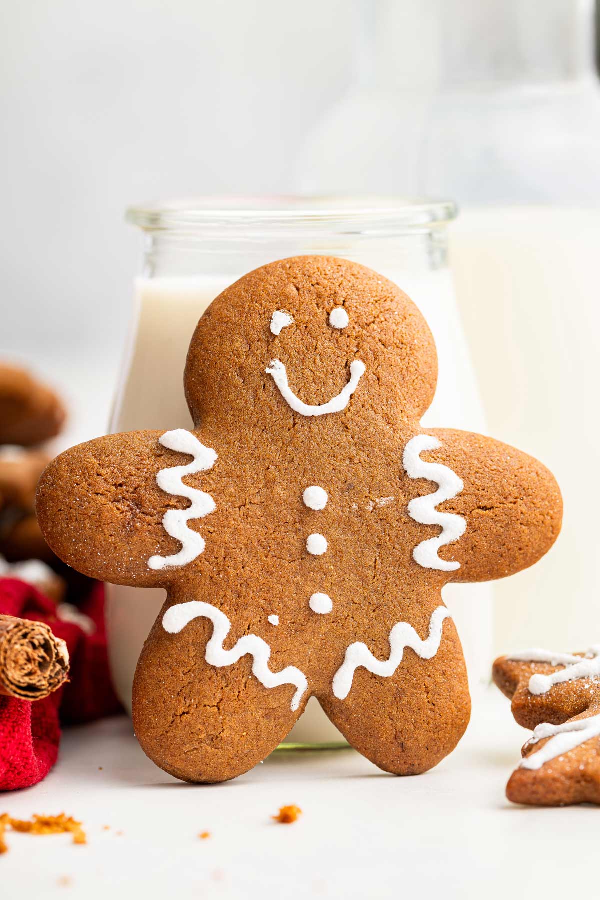 gingerbread man cookie leaning against a jug of milk.