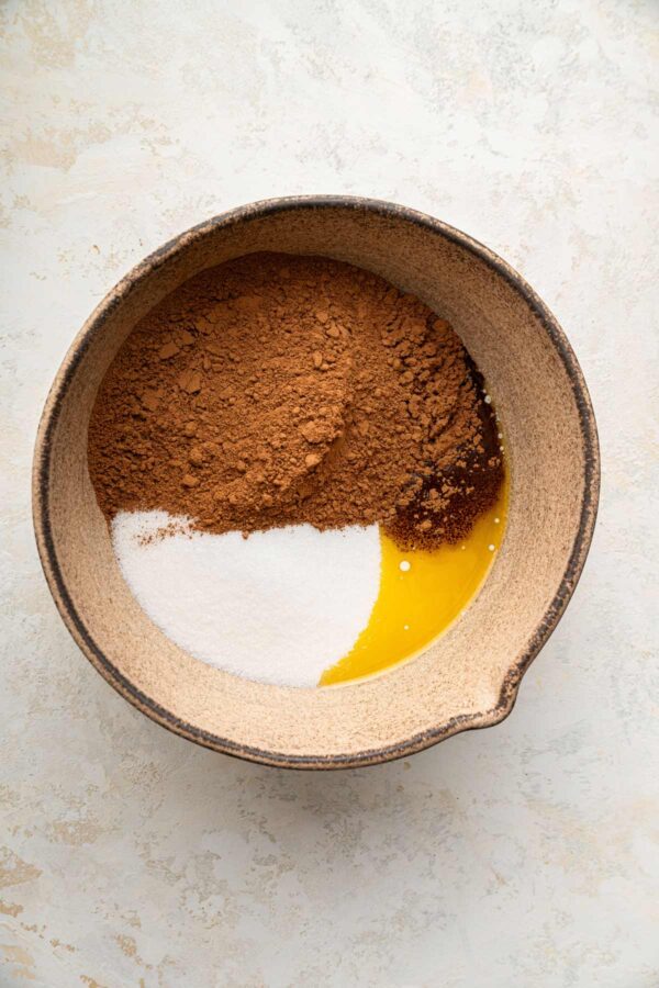 bowl filled with melted butter, sugar, and cocoa powder.