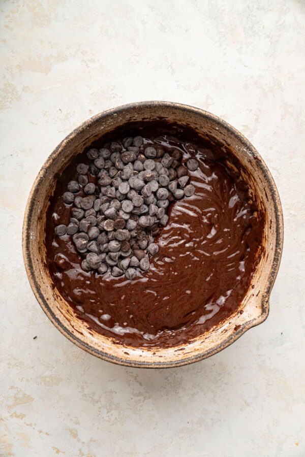 folding chocolate chips into dark chocolatey brownie batter.